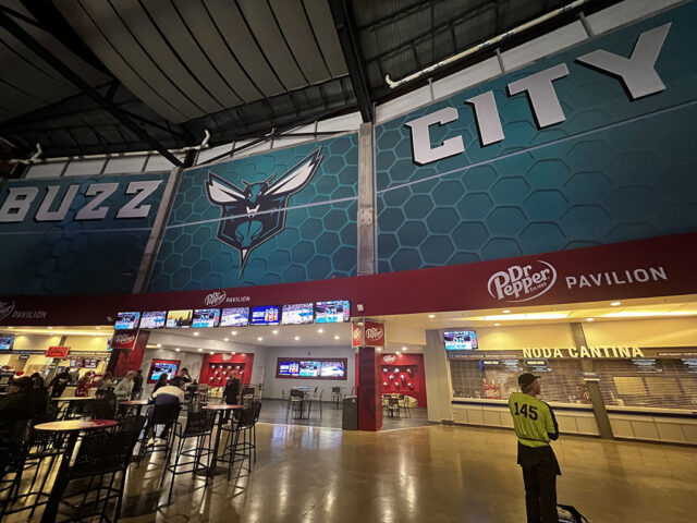 A large "Buzz City" mural hangs over the seating bowl at Spectrum Center in Charlotte