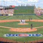 Players talk on the pitcher's mound during a spring training game at Sloan Park in Mesa, Arizona