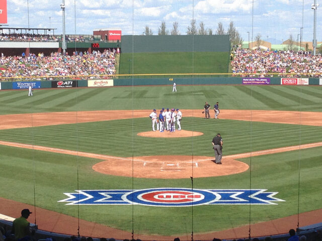 Players talk on the pitcher's mound during a spring training game at Sloan Park in Mesa, Arizona