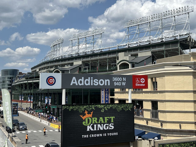 A sign denotes the Addison station on the CTA Red Line in Chicago, with Wrigley Field in the background