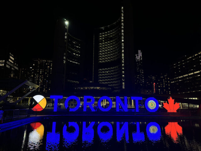 The Toronto sign at Nathan Phillips Square, lit up at night