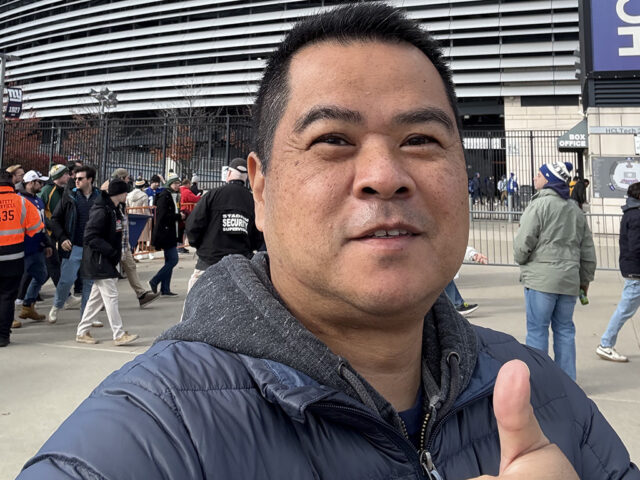 Man standing in front of MetLife Stadium in East Rutherford, New Jersey