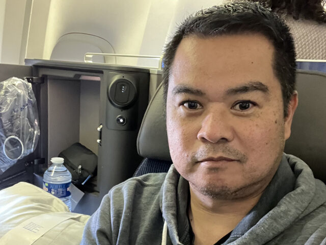 Man sitting in a Polaris business class seat on United Airlines