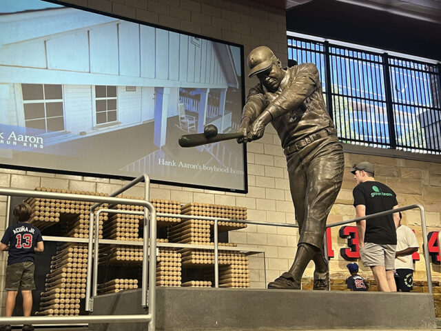 A statue of Hall of Famer Hank Aaron hitting a ball stands in the concourse at Truist Park in Atlanta