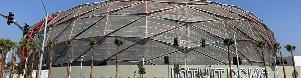 View of the Intuit Dome in Inglewood, with signage in front of the building