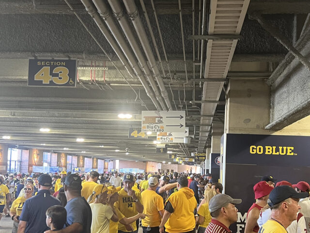 Fans walk through the concourse inside Michigan Stadium in Ann Arbor