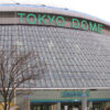 Exterior view of the Tokyo Dome stadium, with lighted green signage