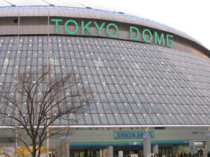 Exterior view of the Tokyo Dome stadium, with lighted green signage