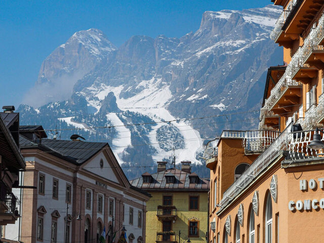 Mountains visible beyond the tops of buildings in the town of Cortina d'Ampezzo, Italy