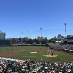 View of the field at Sutter Health Park during an Athletics game, with the yellow Tower Bridge in the background