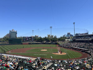 View of the field at Sutter Health Park during an Athletics game, with the yellow Tower Bridge in the background