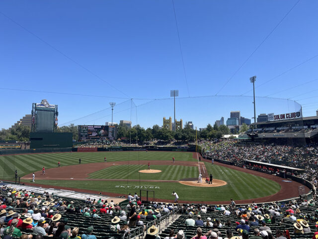 View of the field at Sutter Health Park during an Athletics game, with the yellow Tower Bridge in the background