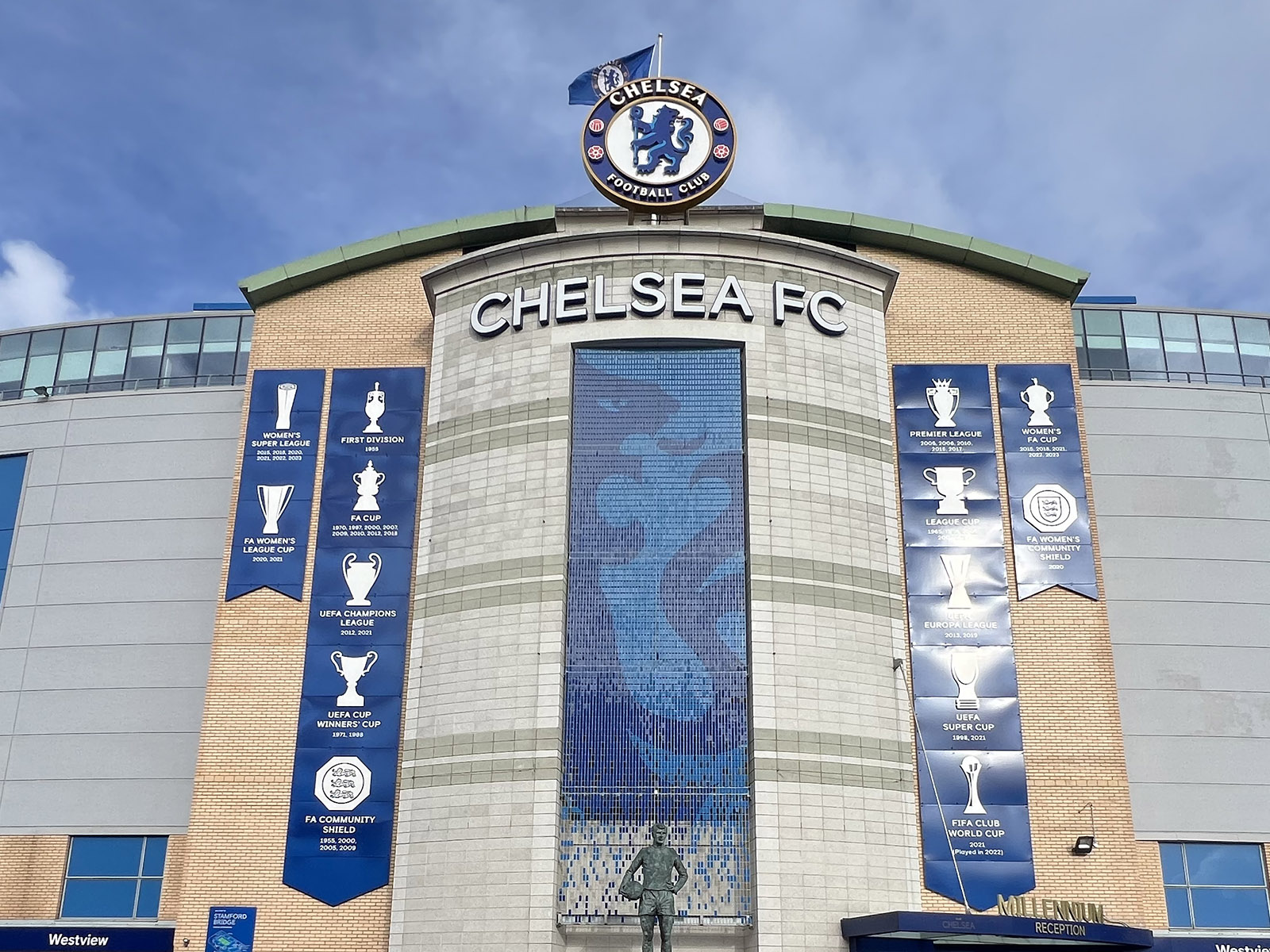 The Chelsea FC logo and signage hang above the exterior to Stamford Bridge, a stadium in London, England