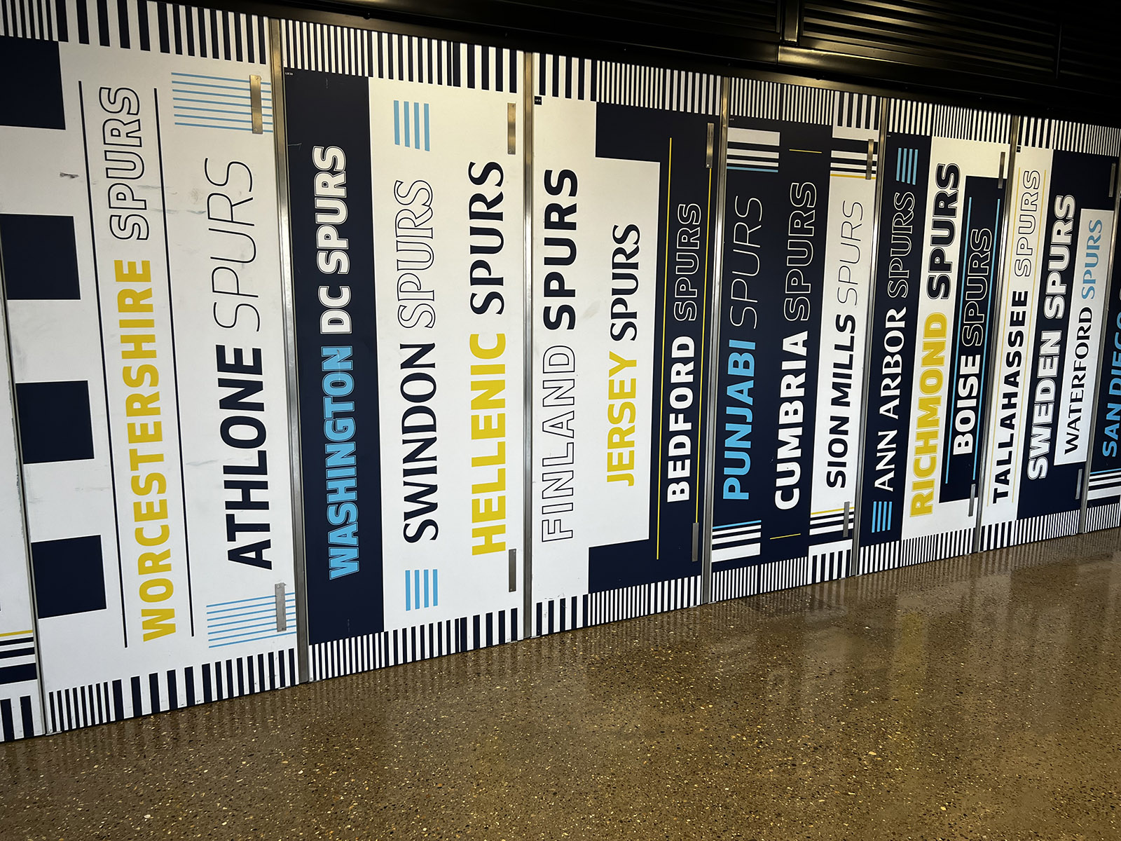 Banners of clubs from cities around the world adorn a wall at Tottenham Hotspur Stadium in London, England