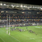 Players gather on the field after an NRL rugby match in Parramatta, Australia