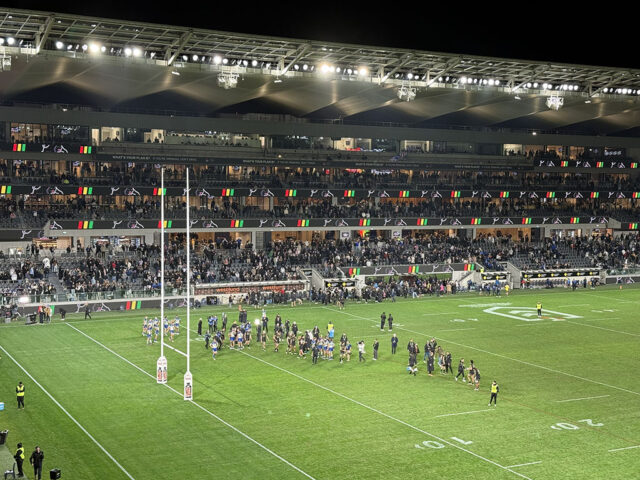 Players gather on the field after an NRL rugby match in Parramatta, Australia