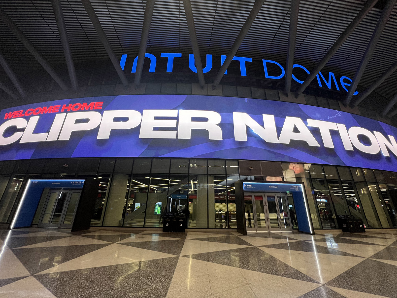 A video marquee is displayed above the entrance doors to the Intuit Dome in Inglewood, California