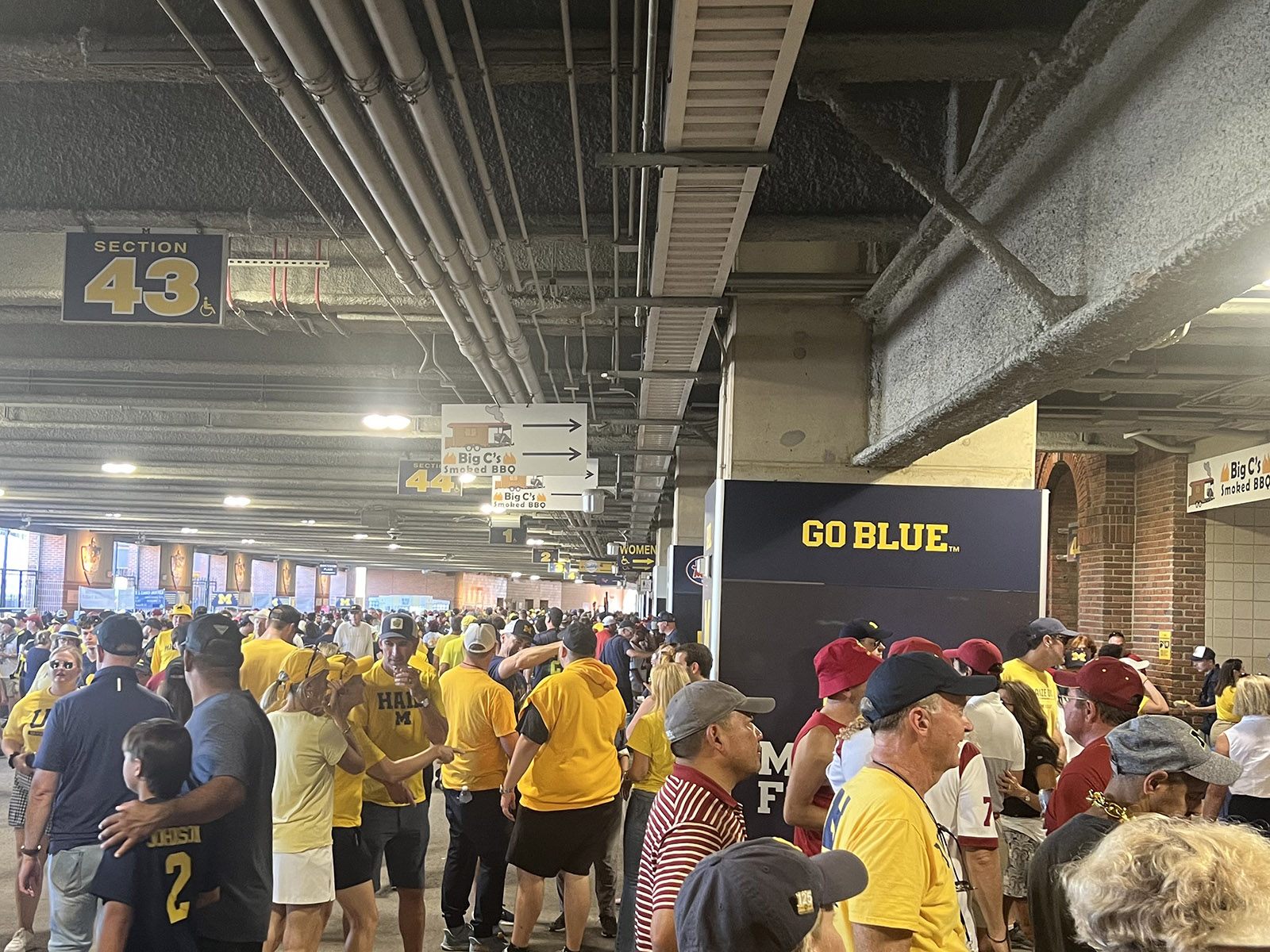 Fans mingle on the course at Michigan Stadium in Ann Arbor before a Wolverines football game