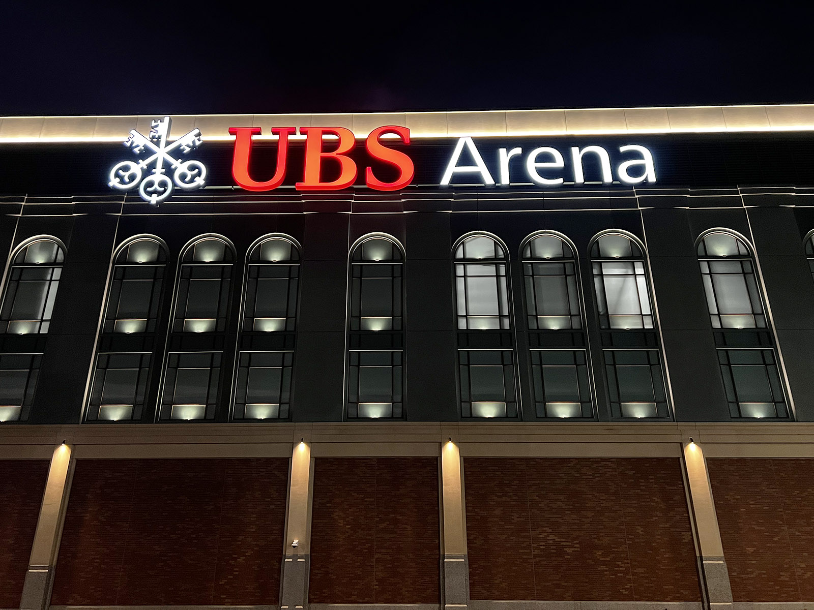Nighttime view of exterior signage in front of UBS Arena in Elmont, New York