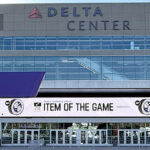 Panoramic view of the exterior of the Delta Center in Salt Lake City, Utah, with the Utah Jazz and Mammoth logos displayed in front