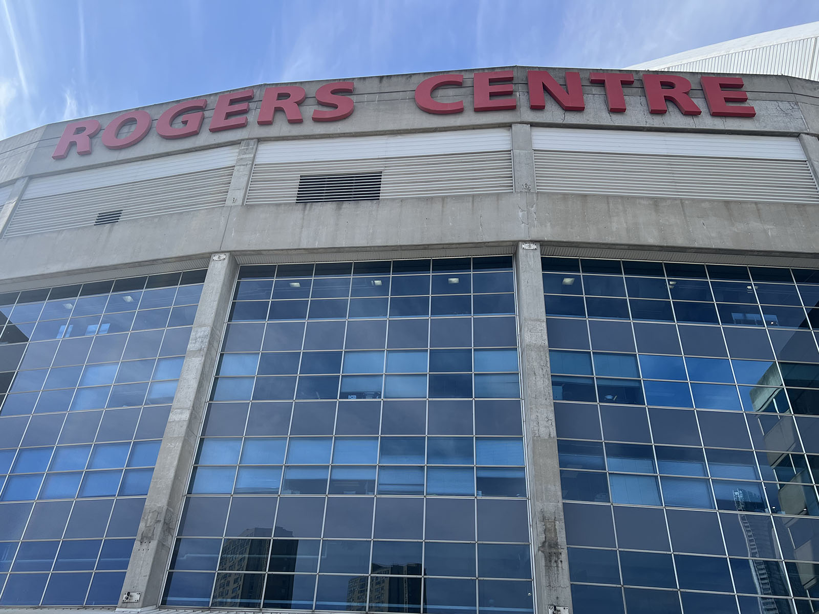 Signage seen above the glass façade at Rogers Centre, a baseball stadium in Toronto, Ontario