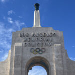The Olympic rings and torch seen on the peristyle of the Los Angeles Memorial Coliseum