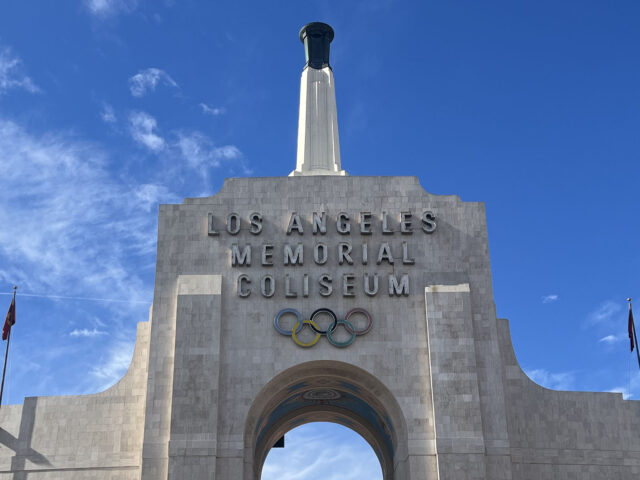 The Olympic rings and torch seen on the peristyle of the Los Angeles Memorial Coliseum